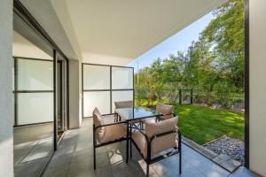 a dining room with a table and chairs on a patio at Le Cocon du Leman in Thonon-les-Bains +9 photos