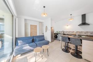 a living room with a blue couch and a kitchen at Le Cocon du Leman in Thonon-les-Bains