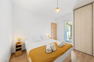 a bedroom with a large bed with towels on it at Le Cocon du Leman in Thonon-les-Bains