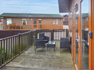 eine Terrasse mit Stühlen und einem Haus im Hintergrund in der Unterkunft The Dragons Den in Ilfracombe + 2 Fotos