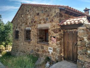 un vieux bâtiment en pierre avec un panneau d'interdiction d'accès dessus dans l'établissement Molino de las Pontezuelas, à Piedrahíta