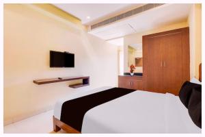 Un dormitorio con una cama y un televisor en la pared. en Hotel Swyamvar Residency Near Vishwanath Temple, en Rāmnagar