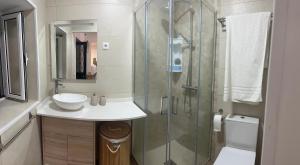 a bathroom with a sink and a glass shower at Mocha Studio in Machico