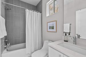 a white bathroom with a toilet and a sink at Sleek City Studio Escape in Durham