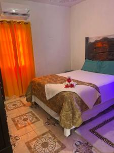 a bedroom with a bed with flowers on it at Tamaras Inn in Ocho Rios +10 photos