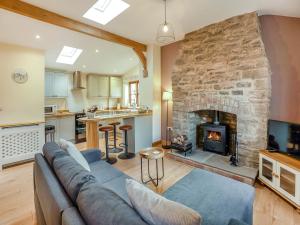 a living room with a couch and a fireplace at Thornycroft Cottage in Llanvair Discoed