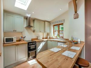 a kitchen with a wooden counter top and a wooden table at Thornycroft Cottage in Llanvair Discoed +11 photos