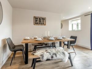 Un comedor con mesa y sillas de madera. en The Dairy - Uk44130, en Baystonhill