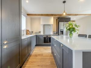 Una cocina con gabinetes grises y un jarrón de flores. en The Dairy - Uk44130, en Baystonhill