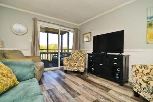 Μια τηλεόραση ή/και κέντρο ψυχαγωγίας στο Inlet Waterfront Steps to Beach w Pool