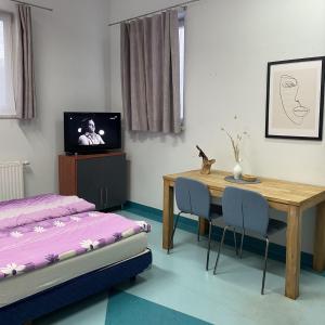 a bedroom with a table and a bed and a television at Hostel Iveda in Świebodzin