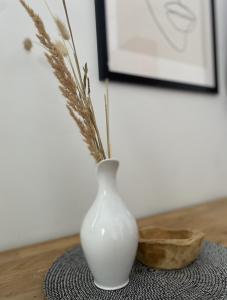 Eine weiße Vase steht auf einem Tisch in der Unterkunft Hostel Iveda in Świebodzin