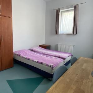 ein kleines Schlafzimmer mit einem Bett und einem Tisch in der Unterkunft Hostel Iveda in Świebodzin