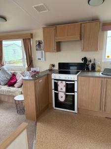 a small kitchen with a stove and a couch at 83 southfield in Skipsea