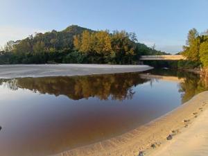 een waterlichaam met een brug op de achtergrond bij Mersing Chalet Teluk Sisek in Kampong Sisek +4 foto's
