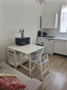 una cucina con un tavolo bianco e un tavolo e sedie di Appartement Chill proche Paris quartier calme proximité de toutes commodités Idéal Professionels et petite famille moins 15 pourcent long séjour a Boulogne-Billancourt