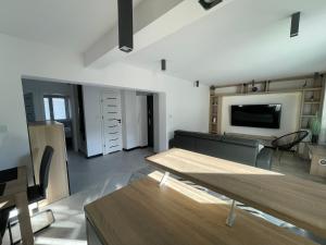 a living room with a table and a tv at 3 Rooms Apartment in Gdańsk