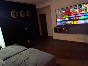 Un dormitorio con una cama y un televisor de pantalla plana. en PANORÂMIC LUXO EXCLUSIVe, en Santa Cruz Cabrália