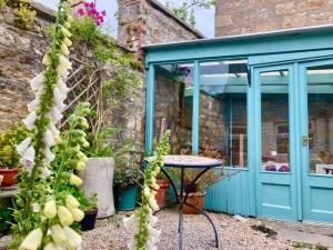 un patio avec une table et une porte bleue dans l'établissement Institution Road, à Elgin