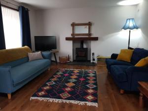 - un salon avec deux canapés bleus et une cheminée dans l'établissement Institution Road, à Elgin