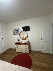 a room with a mirror and a dresser with a red rug at F-House in Padova