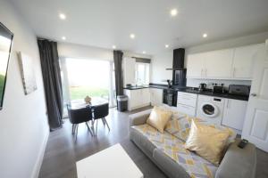 a living room with a couch and a kitchen at HEATHROW AIRPORT apartments-FREE parking-Free underground to and from Heathrow-30 min central London in London