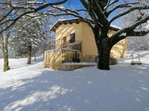 a house with a balcony in the snow at Chalet Monte Alago - Baita in Umbria 