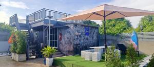 a house with an umbrella in a yard at อู่ตะเภาโฮมสเตย์byต้นไทร in Ban Nong Sa