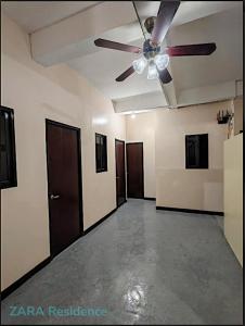 an empty room with a ceiling fan and doors at Zara Residence in Lagao
