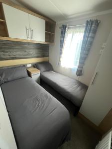 ヘイスティングスにあるLuxury 3 bed swift homeの小さなベッドルーム(ベッド2台、窓付)