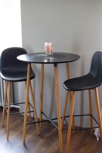 a table with two chairs and a table with a candle on it at Hubane 2-toaline korter in Jõhvi +6 photos