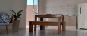 a kitchen with a table and a refrigerator at Garden House Canastra in Delfinópolis