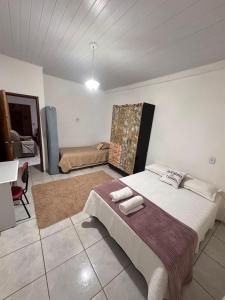 a bedroom with a bed and a desk in it at Chácara Recanto da família in Jacutinga