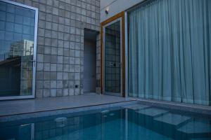 a swimming pool next to a building with a window at Aleela Villa in Chiang Mai