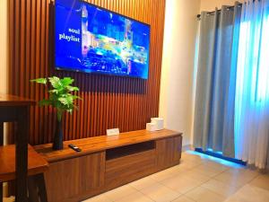 a living room with a television on a wall at Hills Residences by JuJu Staycation in Manila
