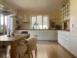 a kitchen with a wooden table and white cabinets at Lovely villa for families and business traveler's in Aalborg +14 photos