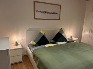 una camera con letto verde con due comodini di Deich-Moment, Apartment 2 auf dem Hundegutshof a Krummendeich