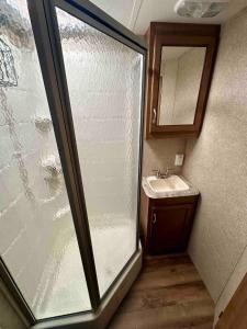 Un baño con ventana de cristal y lavabo. en Riverfront Camper, en Bellevue