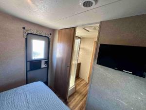 Un dormitorio con una cama y un televisor de pantalla plana. en Riverfront Camper, en Bellevue