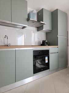 a kitchen with white cabinets and an oven at La Casetta di GioGiò in Agliana +7 photos