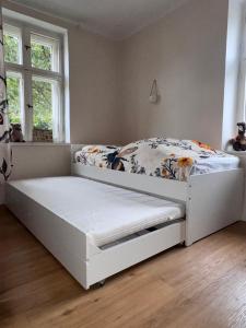 a white bed in a room with a window at Ferienhaus Niemtsch -Alte Schule- in Senftenberg