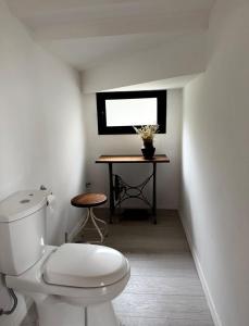 Un baño con inodoro y una mesa con ventana. en Cabaña sustentable en Uribelarrea, en Uribelarrea