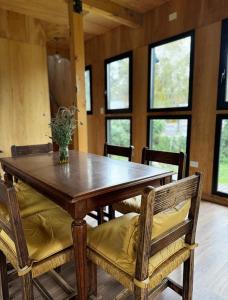 Un comedor con mesa y sillas de madera. en Cabaña sustentable en Uribelarrea, en Uribelarrea 13 fotos más
