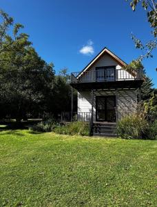 Una casa con un césped verde delante de ella. en Cabaña sustentable en Uribelarrea, en Uribelarrea