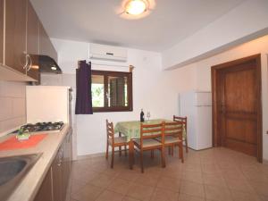a kitchen with a table and chairs and a kitchen with a sink at Apartment in holiday home with private pool garden with grill airco and wifi in Banjole