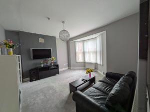 a living room with a couch and a tv at Bay Walk Place in Morecambe