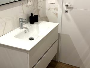 a white bathroom with a sink and a shower at Casa Rockfeller in Alghero