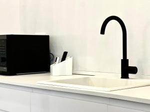 a kitchen counter with a sink and a microwave at Casa Rockfeller in Alghero