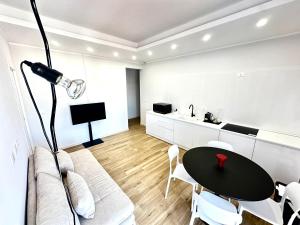 a white living room with a black table and chairs at Casa Rockfeller in Alghero