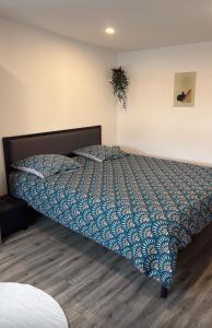 a bedroom with a bed with a blue comforter at Elegant duplex au 3 frontières in Kingersheim